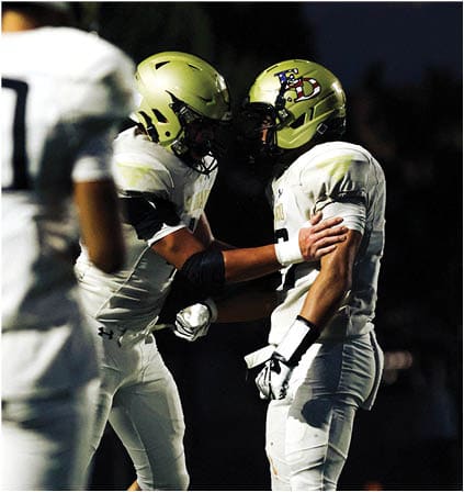 A group of football players celebrating a touchdown. Description generated by AI