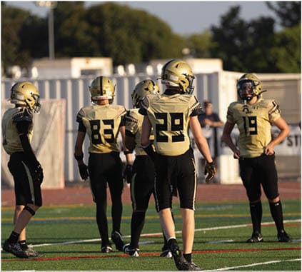 A group of football players on a field. Description generated by AI