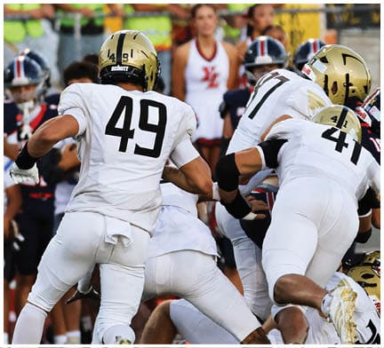 A football game is taking place with a group of men on the field. Description generated by AI
