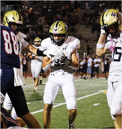 A group of football players celebrating a touchdown. Description generated by AI