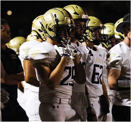 A group of football players on a field. Description generated by AI