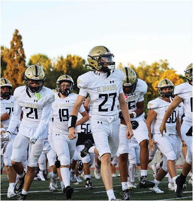 A group of football players celebrating a touchdown. Description generated by AI
