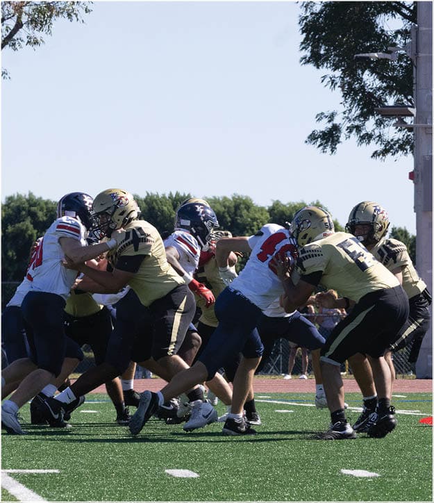 A group of football players on a field. Description generated by AI