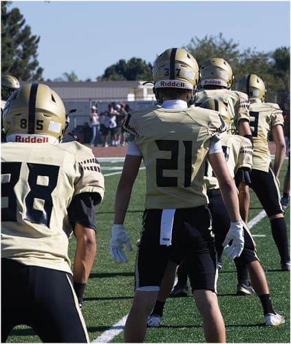 A group of football players on a field. Description generated by AI