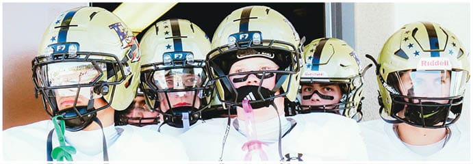 A football game is taking place on a field with players wearing blue and white uniforms. Description generated by AI