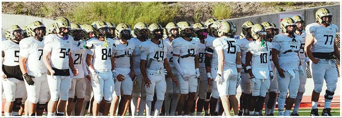 A football game is taking place on a field with players wearing blue and white uniforms. Description generated by AI