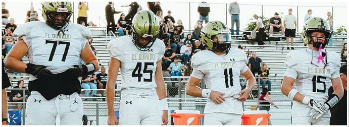 A group of football players on a field. Description generated by AI
