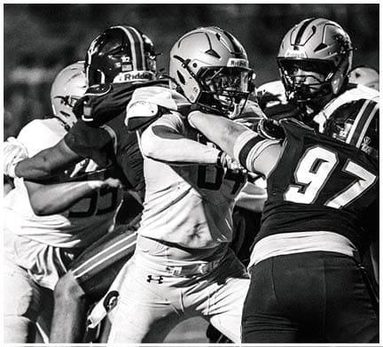 A football game is taking place with a group of men on the field. Description generated by AI