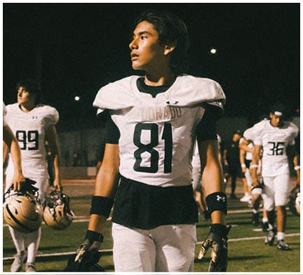 A football game is taking place with a group of men on the field. Description generated by AI
