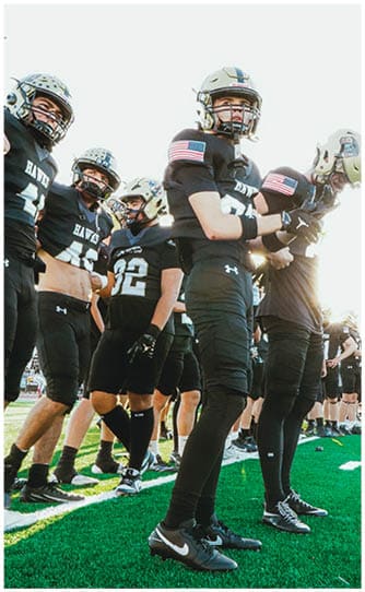 A group of football players on a field. Description generated by AI