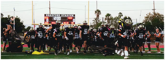 A group of football players on a field. Description generated by AI