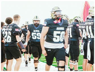 A group of football players on a field. Description generated by AI