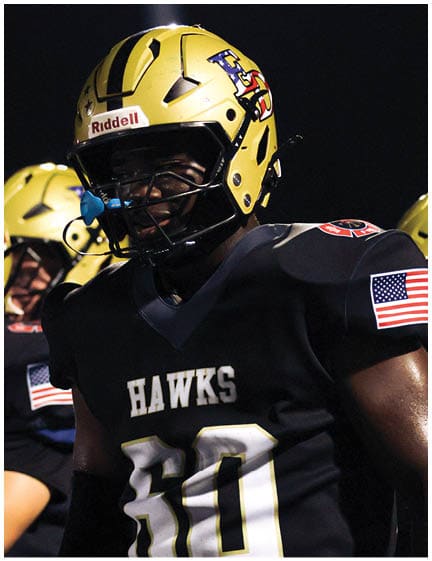 A football player wearing a blue and red jersey. Description generated by AI