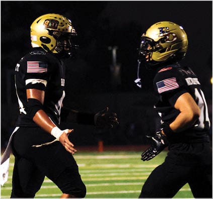 A group of football players on a field. Description generated by AI