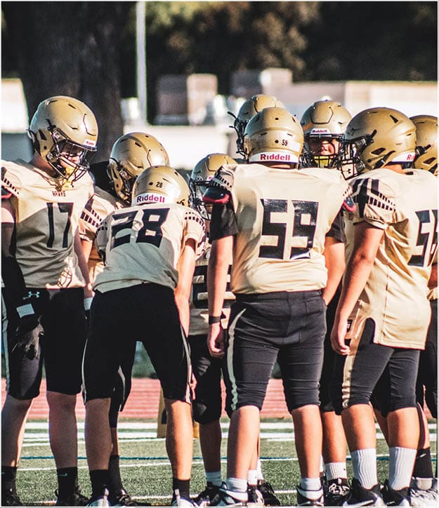 A group of football players on a field. Description generated by AI
