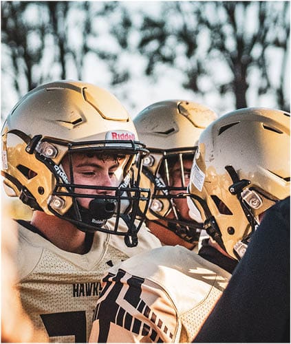 A group of football players on a field. Description generated by AI
