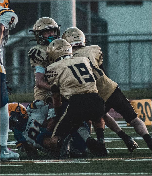 A group of football players on a field. Description generated by AI