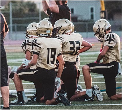 A group of football players on a field. Description generated by AI