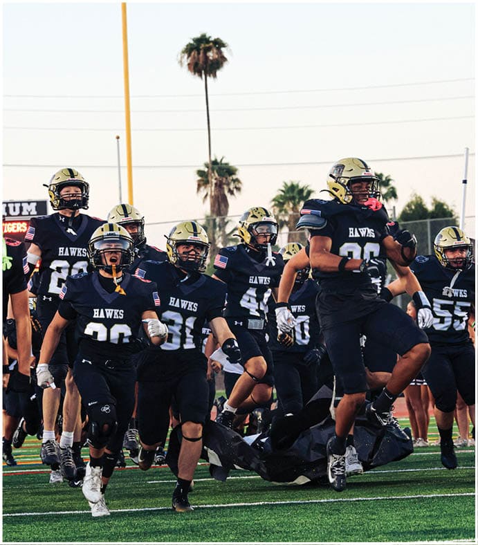 A group of football players on a field. Description generated by AI
