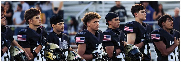 A football game is taking place on a field with players wearing blue and white uniforms. Description generated by AI