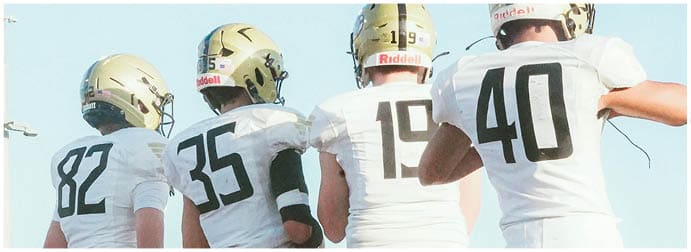 A group of football players on a field. Description generated by AI