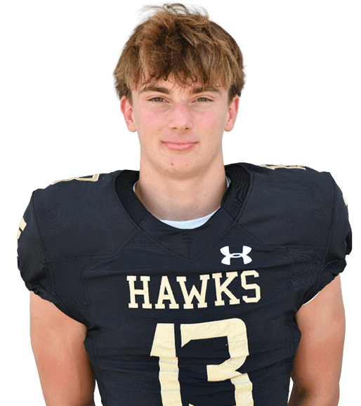 A person with tousled hair wearing a black football jersey with the word “HAWKS" and the number 13 stands against a white background. Description generated by AI