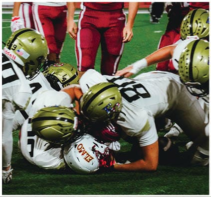 A group of football players on a field. Description generated by AI