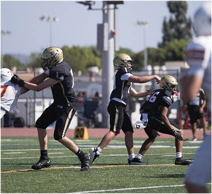 A group of football players on a field. Description generated by AI