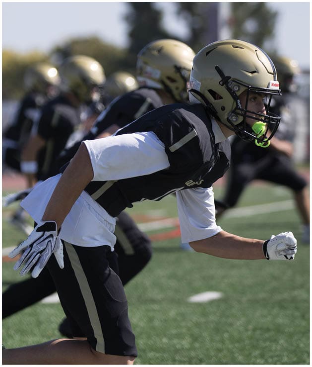 A group of football players on a field. Description generated by AI