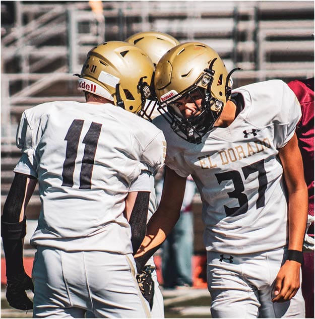 A group of football players celebrating a touchdown. Description generated by AI