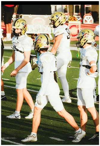 A group of football players celebrating a touchdown. Description generated by AI
