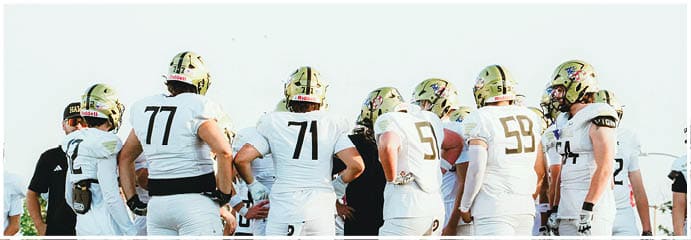 A football game is taking place on a field with players wearing blue and white uniforms. Description generated by AI