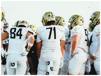 A group of football players on a field. Description generated by AI
