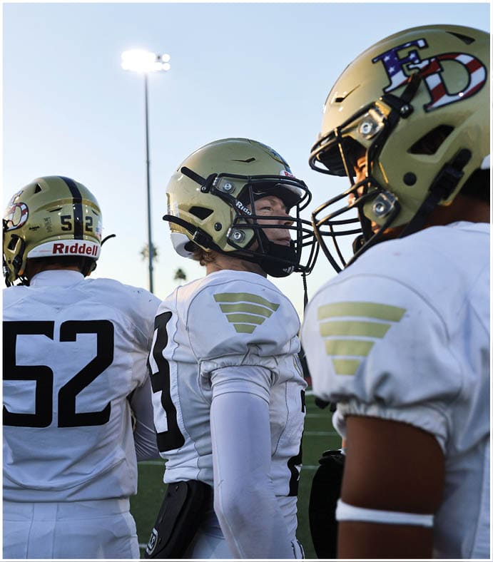 A group of football players on a field. Description generated by AI