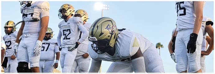 A football game is taking place on a field with players wearing blue and white uniforms. Description generated by AI