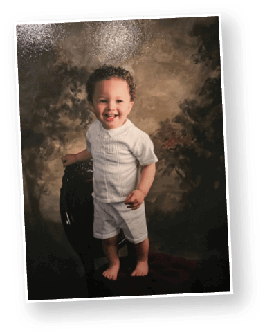 A smiling child with curly hair wearing a white shirt is posed against a brown textured studio backdrop. Description generated by AI