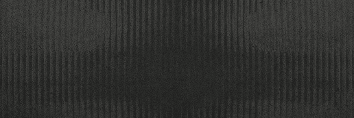 A textured dark surface with vertical ridges and subtle variations in shading. Description generated by AI