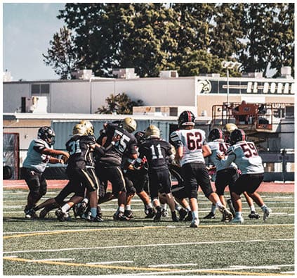 A group of football players on a field. Description generated by AI