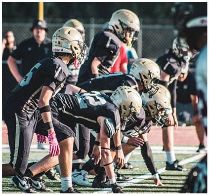 A group of football players on a field. Description generated by AI