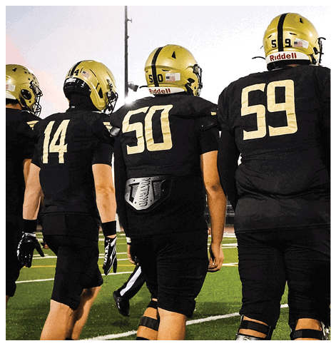 A football player wearing a black jersey with the number 6 on it. Description generated by AI