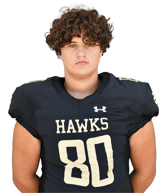 Person with curly hair wearing a black football jersey with the word “HAWKS" and the number 90 on it. Description generated by AI