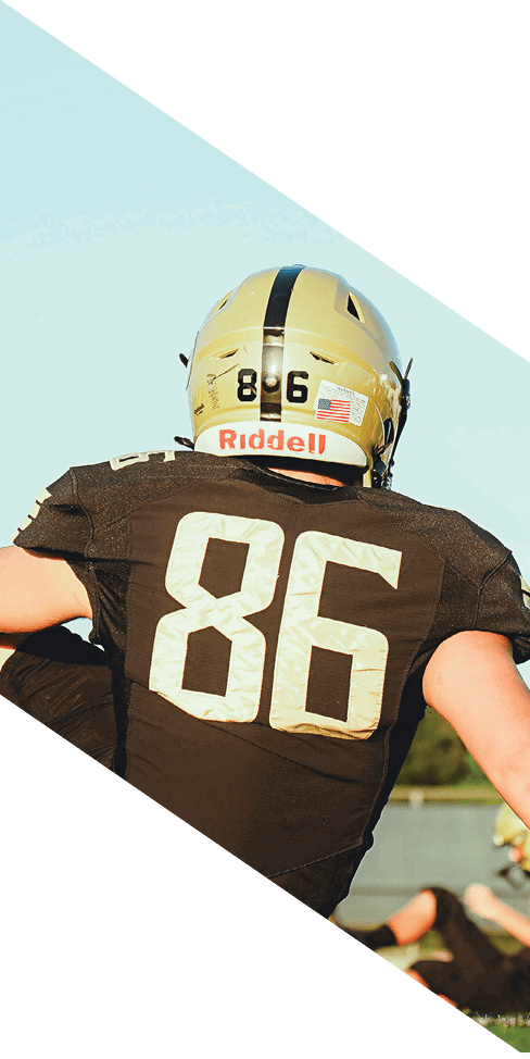 Two men are jumping in the air on a field, both wearing football uniforms. AI generated content