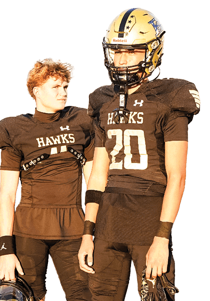 Two people in black football uniforms stand on a field with one holding a helmet and the other wearing a helmet, with a crowd visible in the background. Description generated by AI