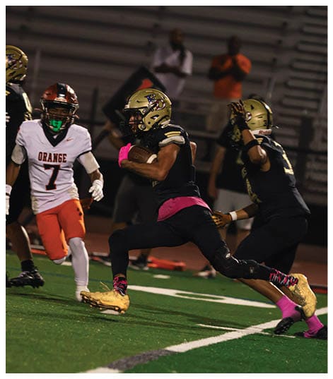A football player wearing a black jersey with the number 6 on it. Description generated by AI