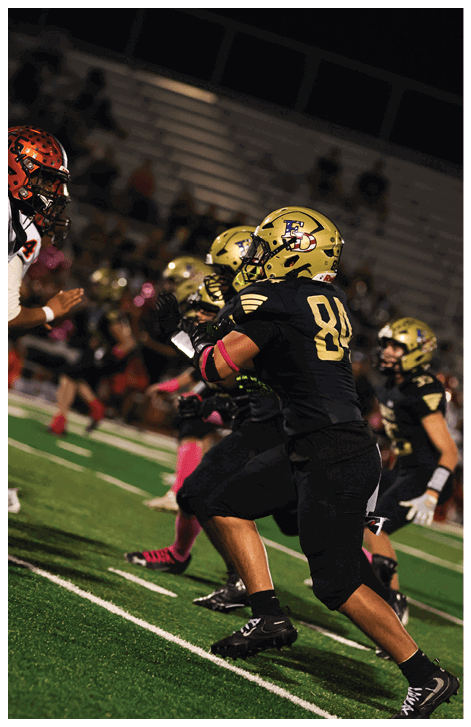 A football player wearing a black jersey with the number 6 on it. Description generated by AI
