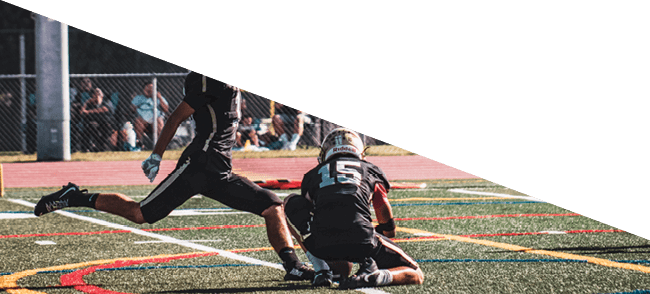 A group of football players kneeling on the field, some with their hands on their heads. AI generated content