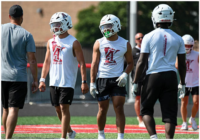 A group of football players wearing black and white uniforms. Description generated by AI