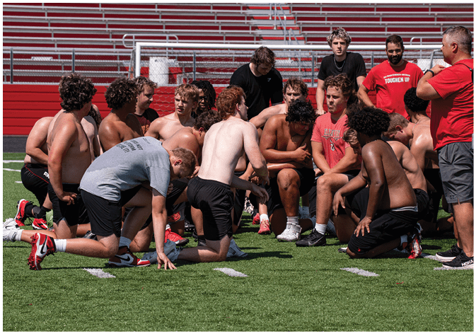 A group of football players wearing black and white uniforms. Description generated by AI