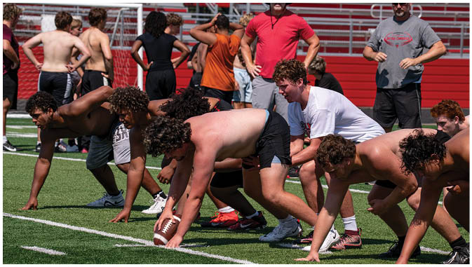 A group of football players on a field. Description generated by AI