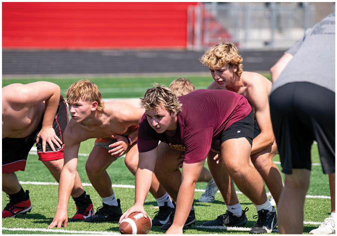 A group of football players wearing black and white uniforms. Description generated by AI
